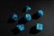 Set of blue role-playing game dice on a black surface