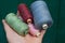 Set of bobbins with colored threads on the palm of a hand