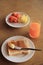 Set of breakfast, plate of toast with butter and fresh fruit and orange juice