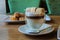 A set of cakes in a cafe with green tea, coffe and marshmallows