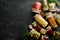 Set of canned vegetables and mushrooms in glass jars. Set of pickled food on black stone background.