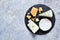 A set of cheeses: brie, blue cheese, parmesan, camembert on a slate board. Plate with delicacies. View from above