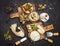 A set of cheeses. Halumi, cheese sticks, Suluguni, Camembert,  fresh soft white burrata cheese ball, mozzarella on a wooden board