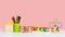 A set of children`s toys on a pink background. Wooden sorter, cubes, pencils and a maze with beads. The concept of eco-friendly