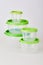 Set of circle transparent plastic food storage containers with green lids isolated