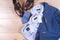 Set of classic mens clothes - blue suit, shirts, brown shoes, belt and tie on wooden background.