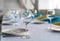 Set of clean empty wine glasses and plates on a dining table with colorful chairs on a restaurant interior pastel background. A cl