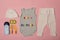 Set of clothes and accessories for newborn. Colored inscription happy birthday on a pink background