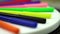Set of color markers lying on desk on blurred background