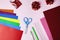Set of color papers, stationery and shiny hearts for Valentine`s day card crafts on pink background. DIY concept.