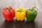 Set of colored bell peppers on wooden background