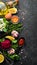 Set of colored sauces and spices on black stone background.