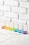 Set of colored vodka glasses against white brick wall