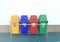 Set of colorful garbage bins, trash can on the cement floor. Yellow, blue, red and green recycle bins with recycle symbol.