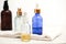 Set of colorful glass bottles with skin care products on white background with copy space. Face serums, acids and packages for