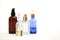 Set of colorful glass bottles with skin care products on white background with copy space. Face serums, acids and packages for