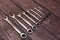 Set of combination wrenches on a wooden background. top view.