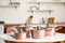 Set of copper cooking pots on table in kitchen