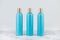 Set of cosmetic bottles, collection of three empty blue bottles of shampoo or lotion on white background