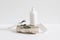 Set of cosmetic products on light background. White plastic pump bottle for shampoo, lotion mockup on stone podium
