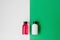 Set of cosmetic products for shower or bath, white and pink bottles on white and green background.