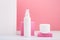 Set of cosmetic tube and jar against pink background and white wall with stripes