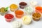 Set of cups of various sauces and condiments for dipping on white background