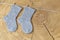 Set of cute knitted cashmere newborn baby socks hanged on pins against wooden background