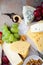 Set of delicatessen Cheeses with grapes and walnuts on the slate background