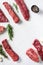 Set of different alternative types of raw beef steaks,on a white stone background top view concept frame in corners space for text