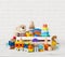 Set of different children toys on wooden table near wall
