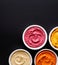 Set of different colorful hummus on a black background