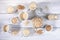 Set of different glass containers with oat milk, oat seeds and flakes on white wooden table.