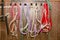 A set of different halters for horses hang on hooks, on a wall of a stall in a stable