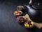 Set of different herbal and fruit dry teas in clay bowls,black clay teapot, dark moody, stone,concrete background