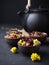 Set of different herbal and fruit dry teas in clay bowls,black clay teapot, dark moody, stone,concrete background