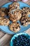 Set of easy to prepare and healthy, homemade oatmeal and blueberry cookies - on beautiful blue plate. Bowl full of blueberries