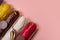 Set of eclairs with different fillings on a pink background.