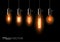 A set of five different lamps of Edison, weigh on the wires. On black background.