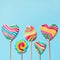 Set of five rainbow colorful lollipops isolated on blue background.