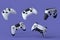 Set of flying gamer joysticks or gamepads on violet background