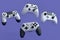 Set of flying gamer joysticks or gamepads on violet background