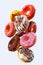 Set of flying glazed donuts with sprinkles on a white background