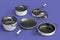 Set of flying stewpot, frying pan and chrome plated cookware on violet