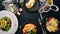 A set of food. Shakshuka, omelette, avocado salad, sandwich with poached egg. On a wooden background.