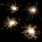 Set of four bright burning sparklers on a black background