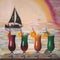 Set of four cocktail drinks on table. Colored Beverage in long glass goblets with orange slices and straws. Sailboat on