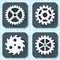 Set of four flat gear icons with long shadows on a graph engineering paper background.