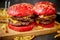 Set of four homemade giant double becon cheese burgers. Served with french fries on wooden board.