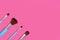 A set of four makeup brushes on a pink background
